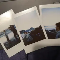 Trzy zdjęcia jak z instaxa: chłopiec na plaży, para na skałach i chłopiec patrzący na morze.