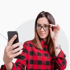 Kobieta w okularach robi sobie selfie telefonem. Czy zdjęcie do dowodu może być w okularach? Tak, jeśli nie zasłaniają twarzy.